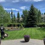 Gardener mowing a large garden lawn