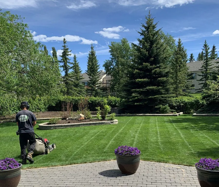 Gardener mowing a large garden lawn